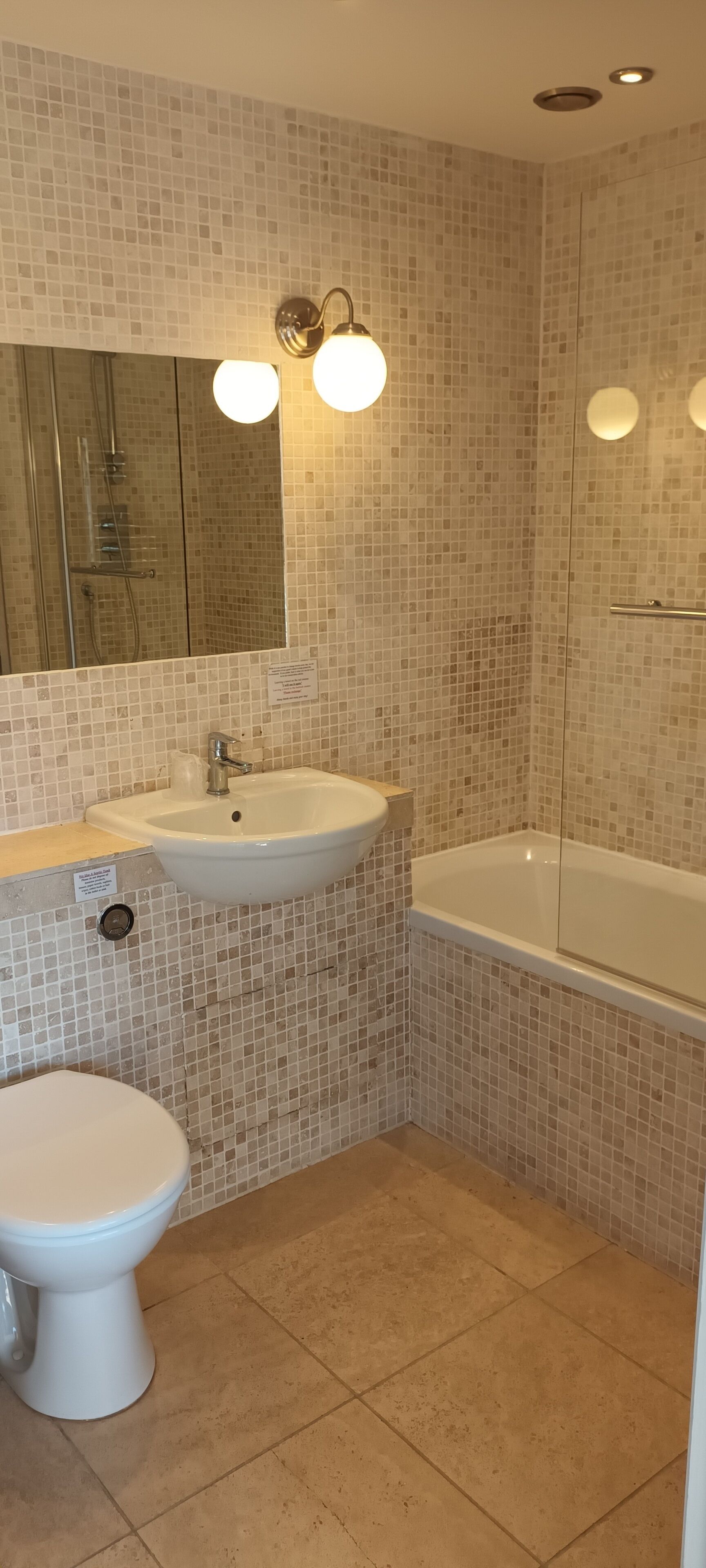 Un baño con un lavamanos blanco, un inodoro y una bañera.