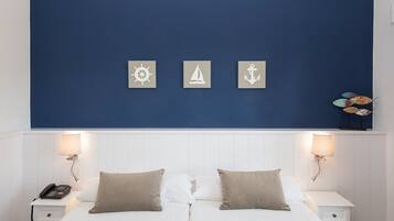 A double bed with two bedside tables, each with a lamp and a phone.
