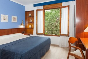 Une chambre à coucher avec un lit, un bureau et une fenêtre avec des rideaux.
