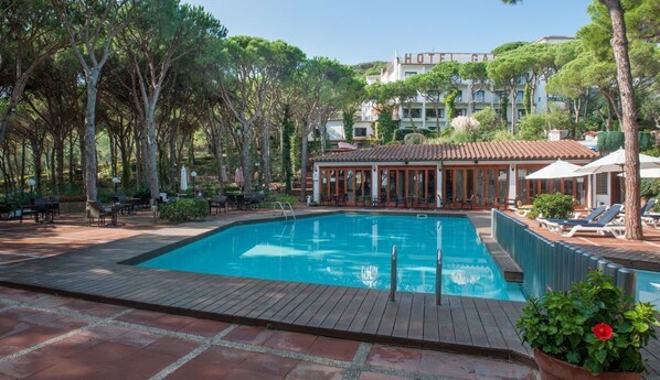 Una piscina al aire libre, tumbonas