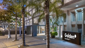 A hotel entrance with palm trees, a sign reading "Golden Acqua Salou," and a modern building facade. - Golden Acqua Salou (Salou)