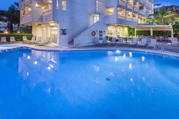 A hotel with a swimming pool, outdoor seating, and a covered area. - Golden Acqua Salou (Salou)