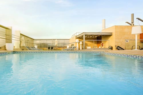 Una piscina al aire libre, tumbonas