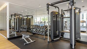 A modern gym with various exercise equipment, including weight machines and dumbbells.