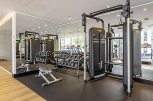 Ett modernt gym med olika typer av träningsutrustning, inklusive styrketräningsmaskiner och hantlar.