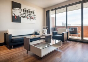 A modern living room with a sofa, a glass coffee table, and a balcony with a view.