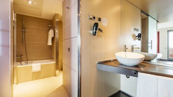 Un baño moderno con bañera, lavamanos grande y ducha.