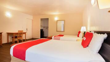 A hotel room with a large bed, a desk, and a chair.