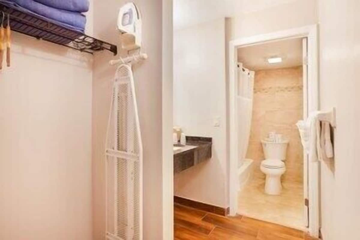 Un baño con inodoro, lavamanos y zona de ducha.