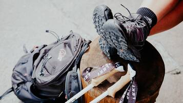 Un tocón de madera con botas de senderismo, una mochila y bastones de trekking.