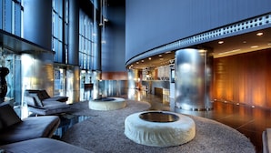 Un hall d’entrée moderne avec des espaces de détente, un comptoir d’accueil et une grande fenêtre.