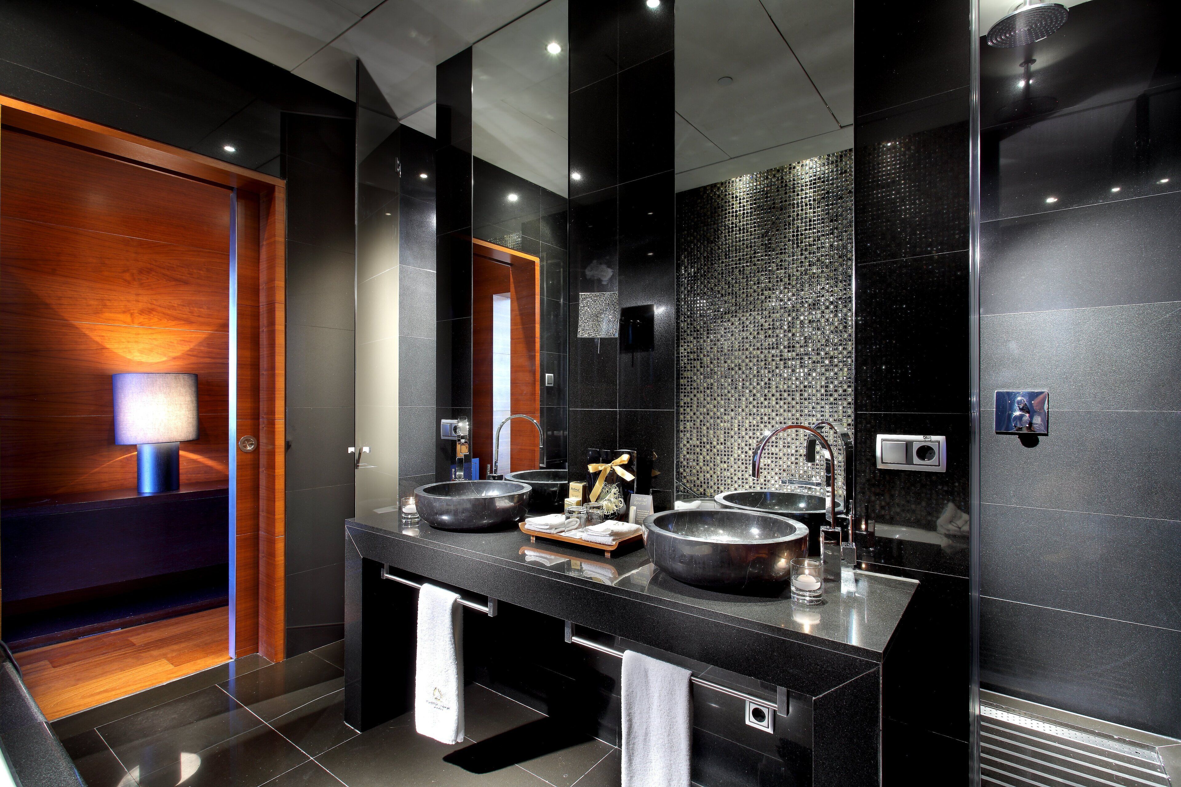 Een moderne badkamer met twee grote wasbakken, een spiegel en een douchehoek.