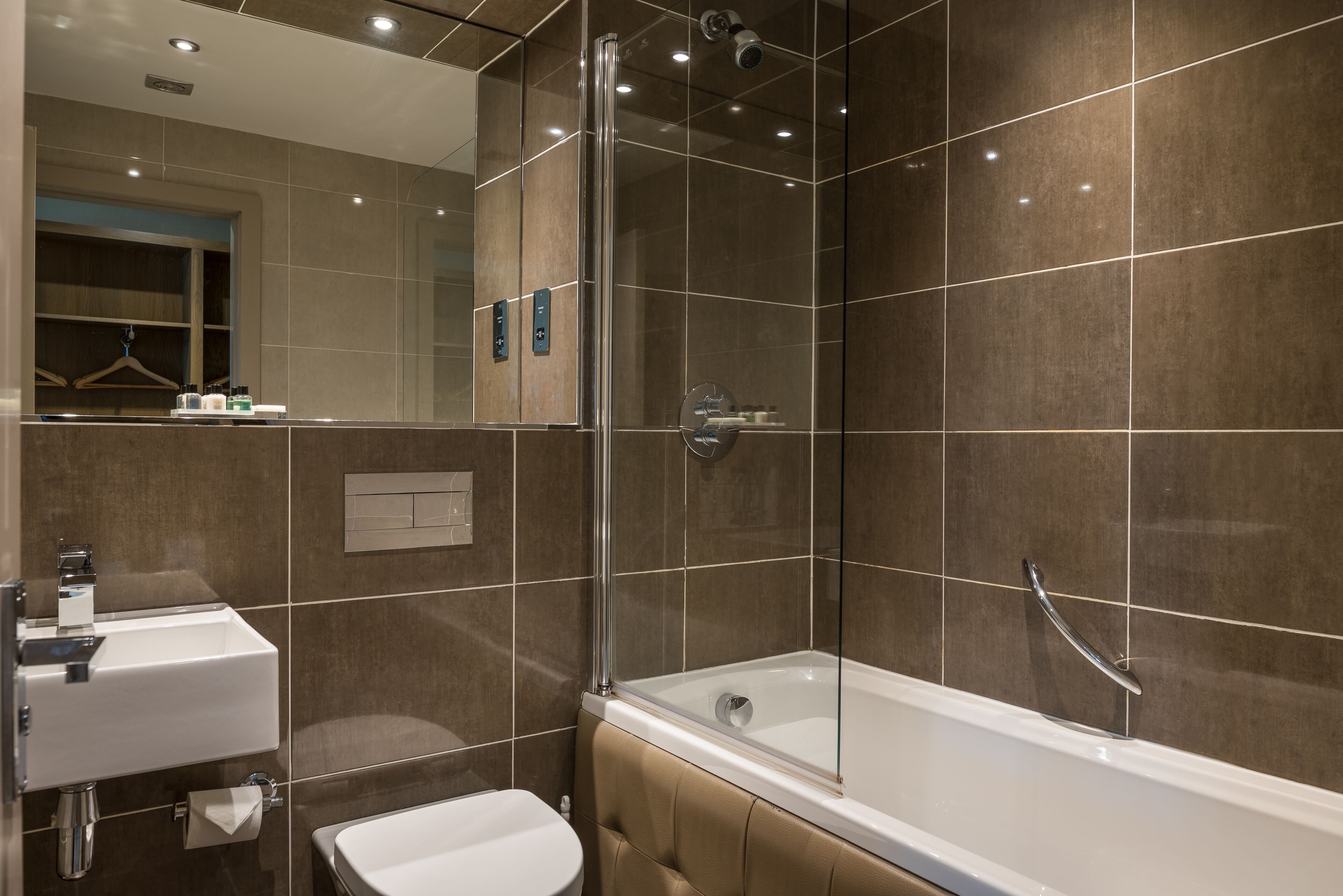 A modern bathroom with a glass-enclosed shower, a white sink, and a bathtub.