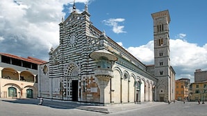 A historic building with a clock tower and a large open plaza. - Hotel Toscana (Prato)