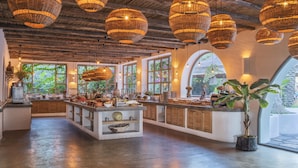 A spacious kitchen with a central island, large windows, and hanging wicker chandeliers. - Flamingo Hotel & Spa - Pet Friendly (Fethiye)