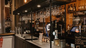 A bar area with a wooden counter, hanging glasses, and shelves stocked with bottles. - Atholl Arms Hotel (Dunkeld)