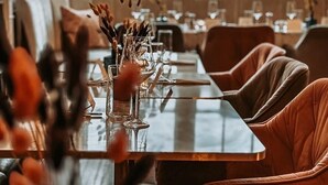 A dining area with a long table set for a meal, surrounded by cushioned chairs. - Atholl Arms Hotel (Dunkeld)