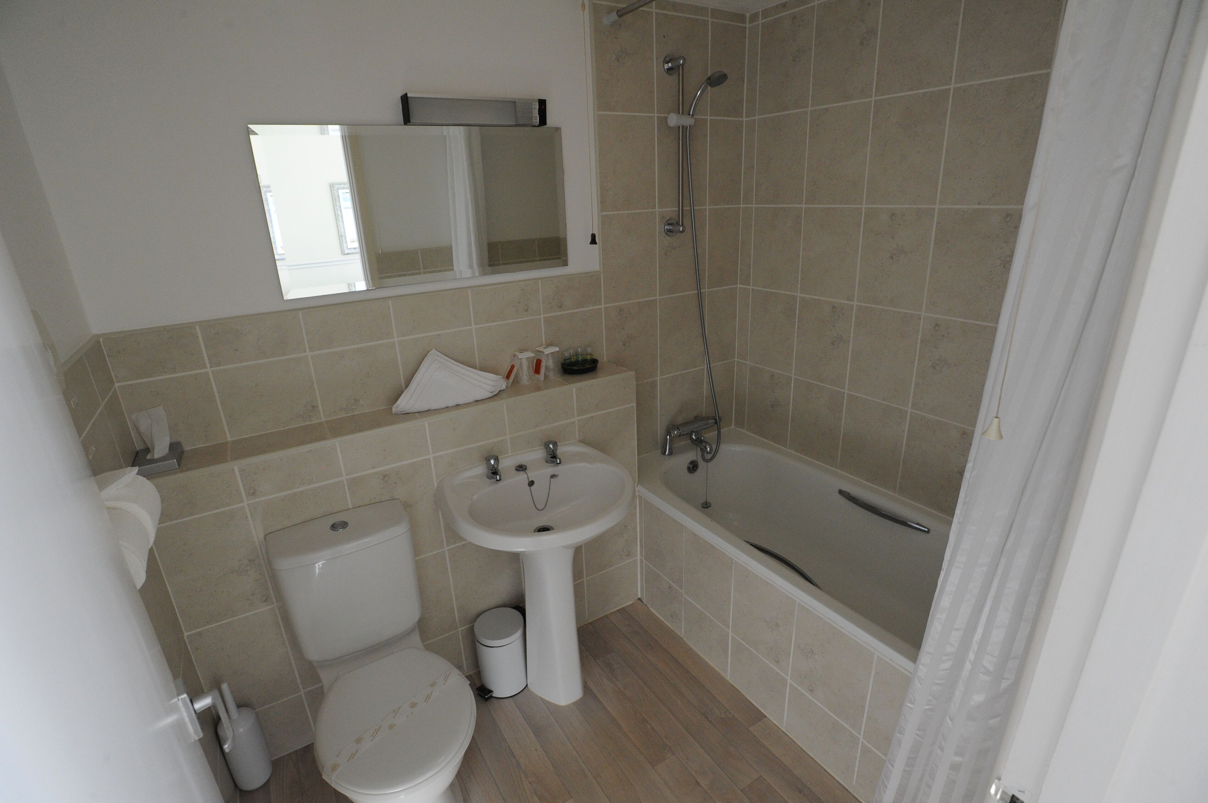 Een kleine badkamer met toilet, wastafel en douche.