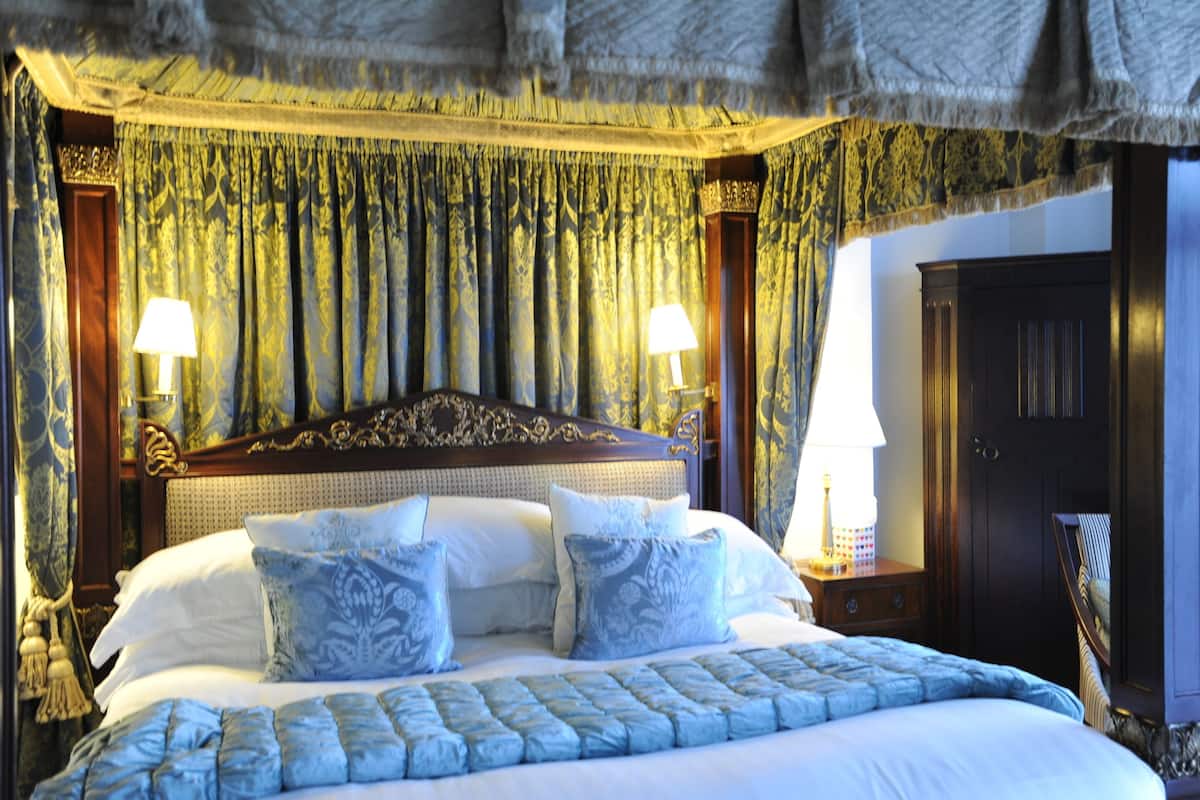 A well-appointed bedroom with a large bed, ornate headboard, and matching curtains.