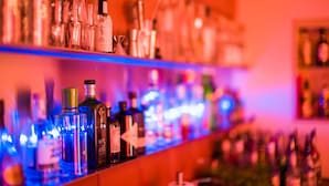 Un bar con varias botellas y vasos, presumiblemente con bebidas alcohólicas.