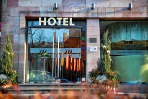 A hotel entrance with a glass door, a sign above it, and a sign indicating the lounge area.