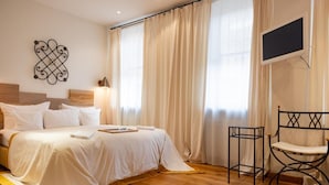 Un dormitorio con una cama, una silla, un televisor y un elemento decorativo en la pared.