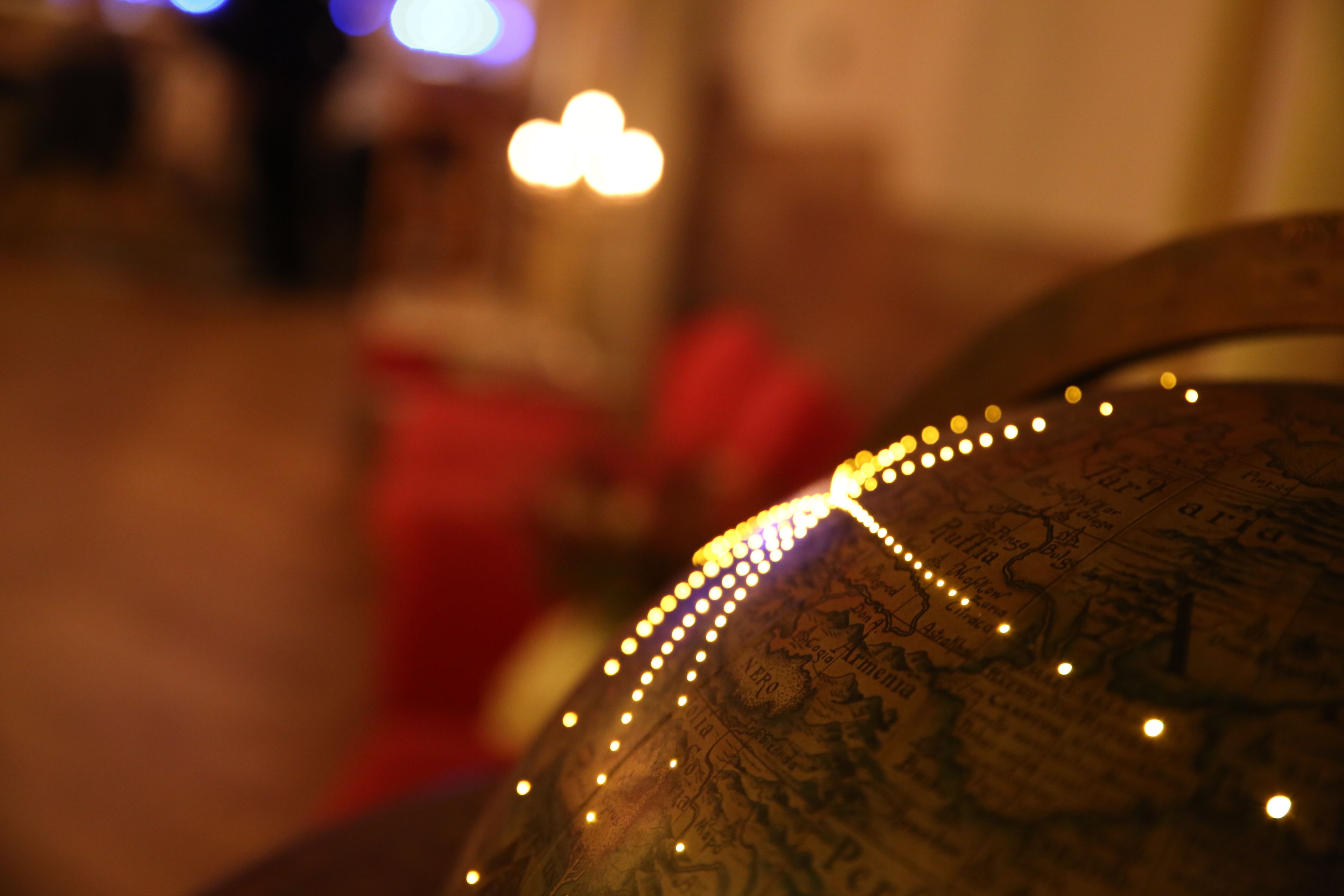 A close-up of a globe with a string of lights.