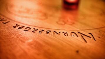 A close-up of a wooden surface with the text "NUNBERGER" engraved on it.