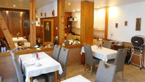 A cozy restaurant with wooden accents, brick walls, and white tablecloths.
