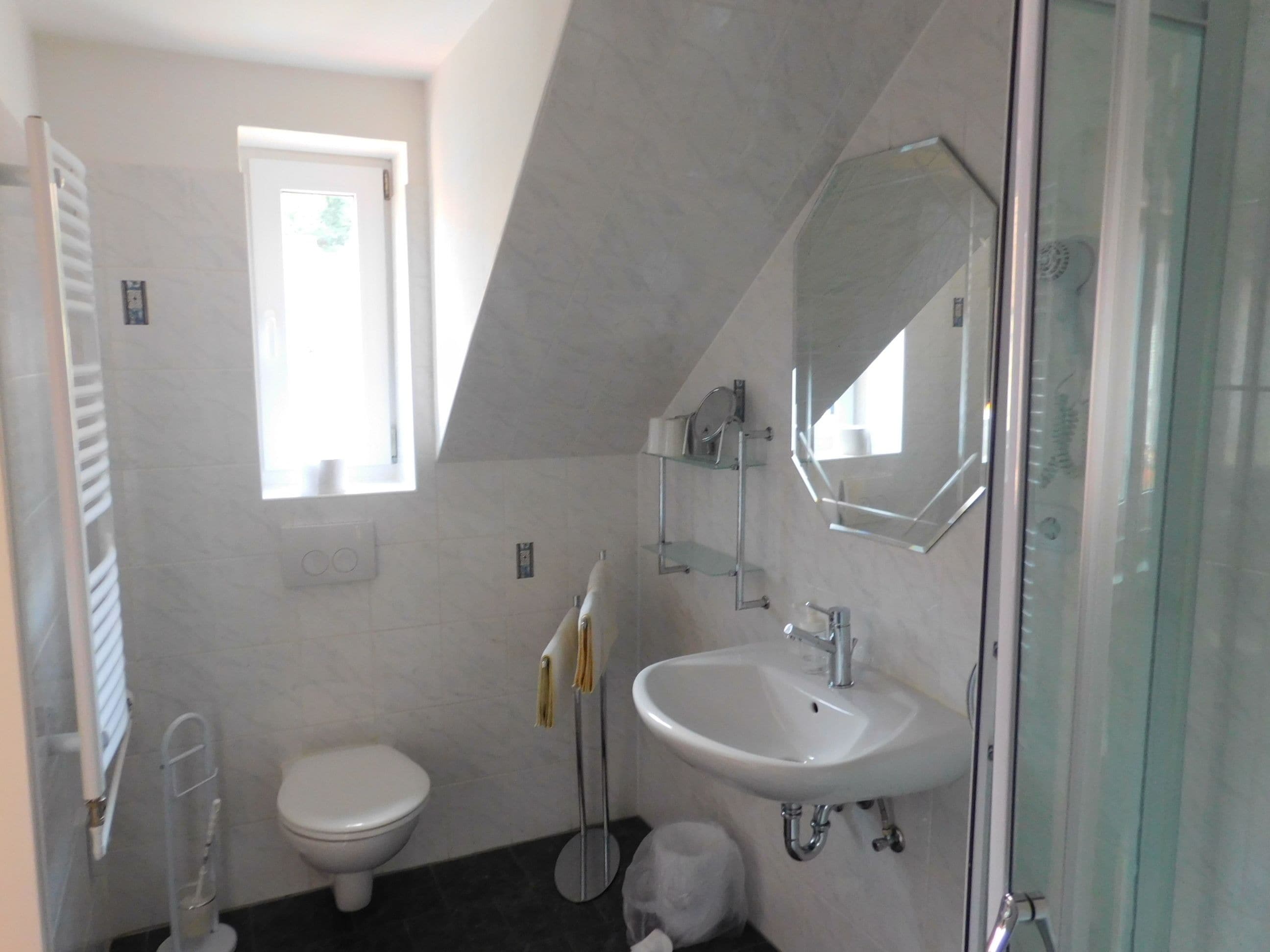 Ein modernes Badezimmer mit Toilette, Waschbecken und Duschbereich.