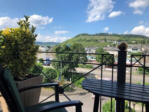 A balcony with a view of a river, a town, and hills in the distance. - Boutique-Hotel Moseltor (Traben-Trarbach)