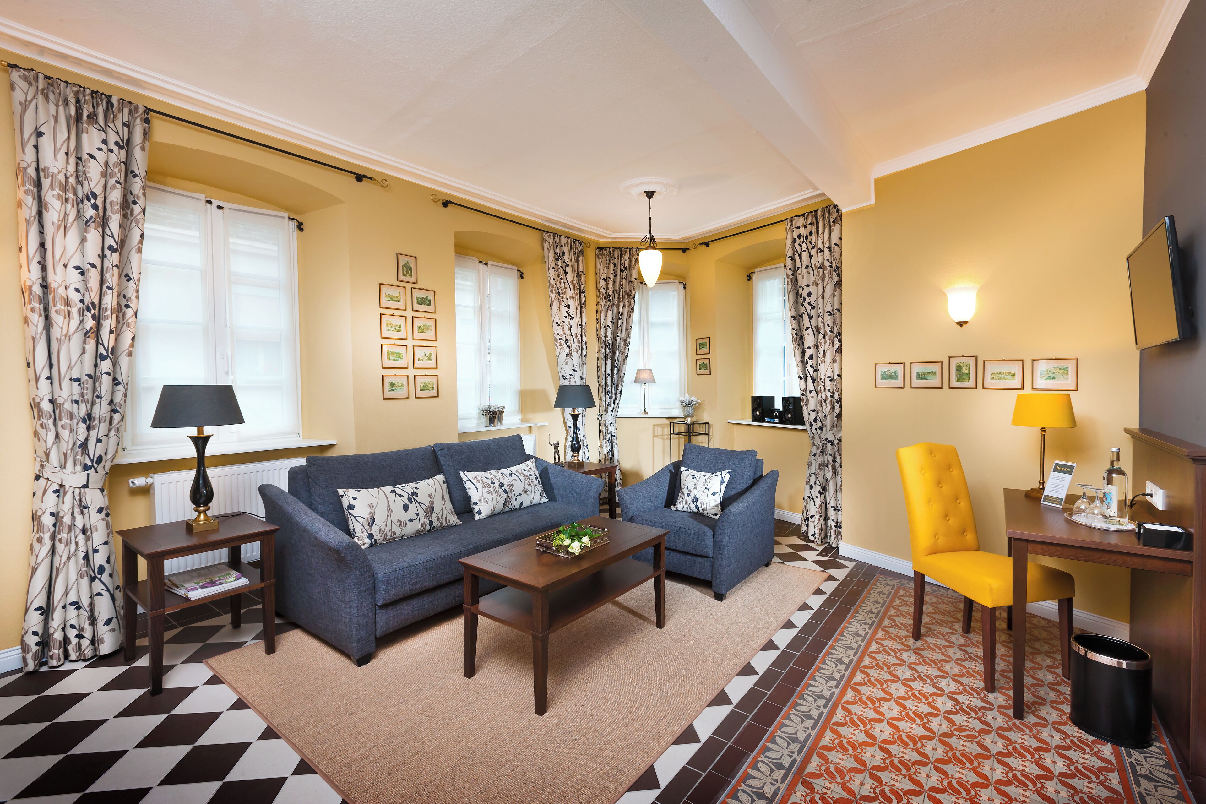 A living room with two sofas, a coffee table, a lamp, a chair, and a television.
