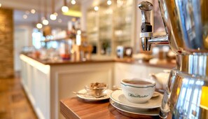 A coffee machine and a bowl of coffee on a table in a hotel setting. - Boutique-Hotel Moseltor (Traben-Trarbach)
