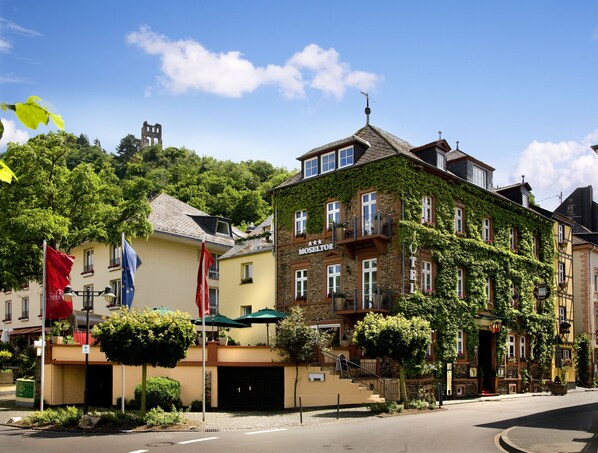 A historic building with a stone facade, a balcony with potted plants, and a sign reading "MOSSELTOR". - Boutique-Hotel Moseltor (Traben-Trarbach)
