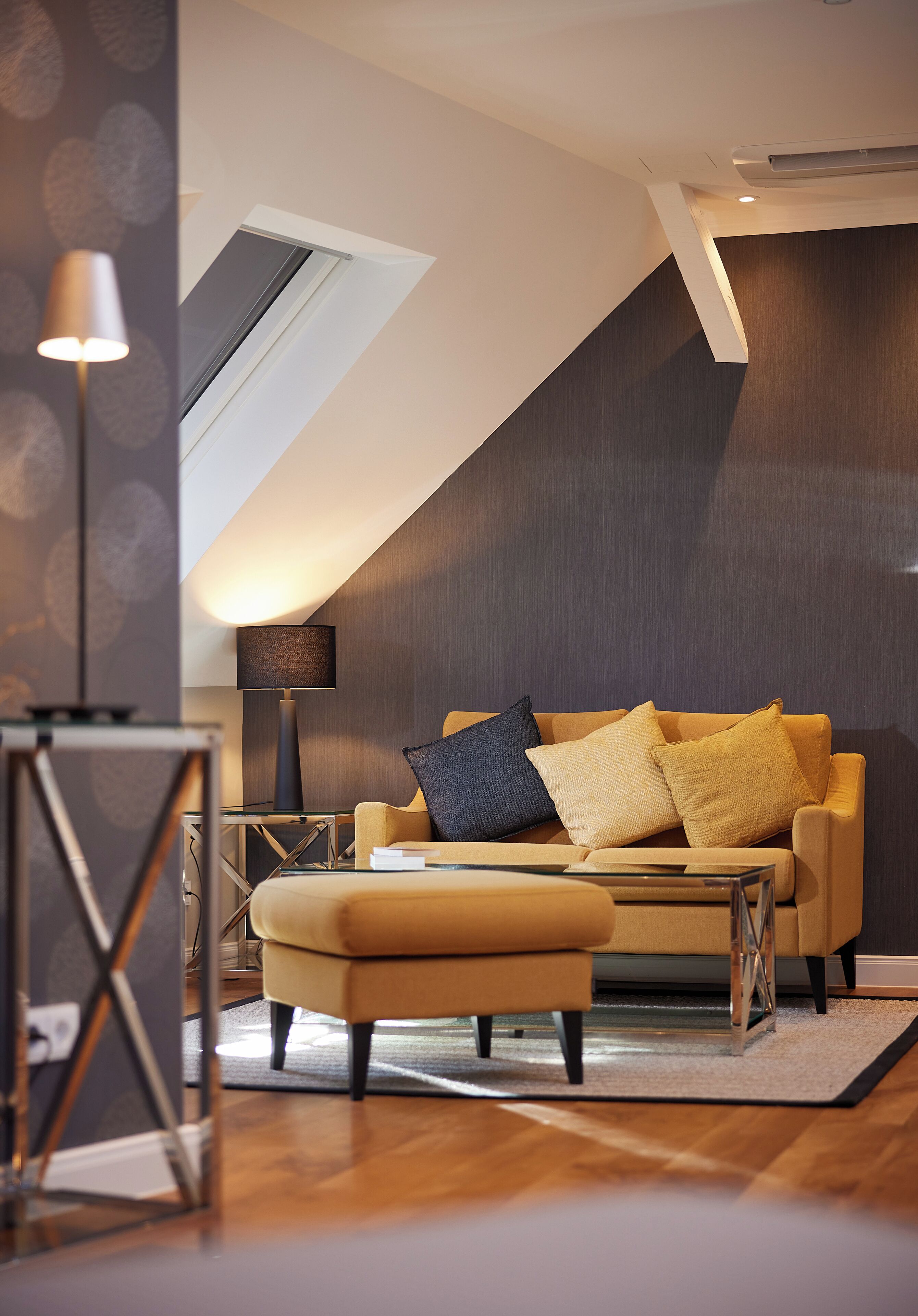 Ein modernes Wohnzimmer mit einer Couch, einem Hocker und einer Lampe.