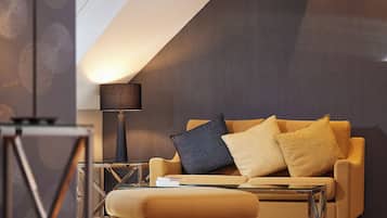 Ein modernes Wohnzimmer mit einer Couch, einem Hocker und einer Lampe.