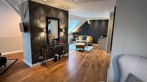 Una sala de estar moderna con un sofá a cuadros de galgo, una mesa de centro y un comedor con mesa y sillas.