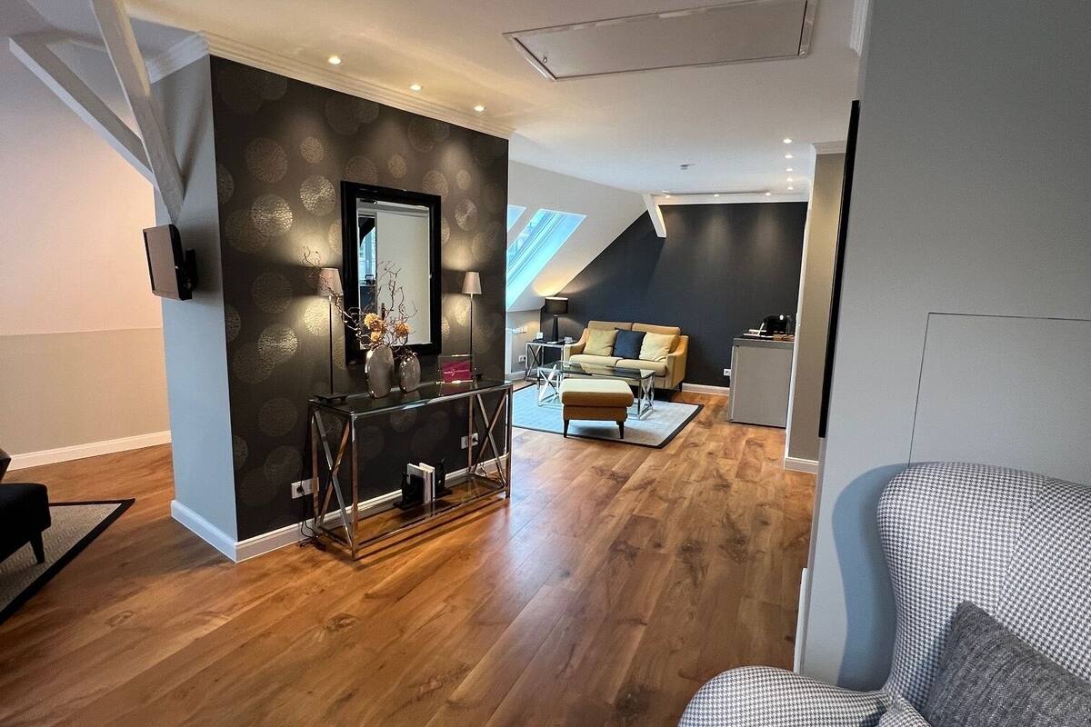 Een moderne woonkamer met een hondentandsofa, een salontafel en een eetgedeelte met een tafel en stoelen.