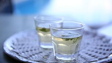 Two clear glasses of water on a silver tray with a textured surface.