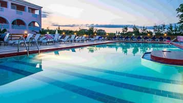 Una piscina al aire libre de temporada, sombrillas