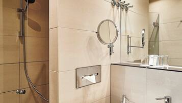 Un baño moderno con ducha, lavamanos y espejo.