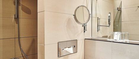 Une salle de bain moderne équipée d’une douche, d’un lavabo et d’un miroir.