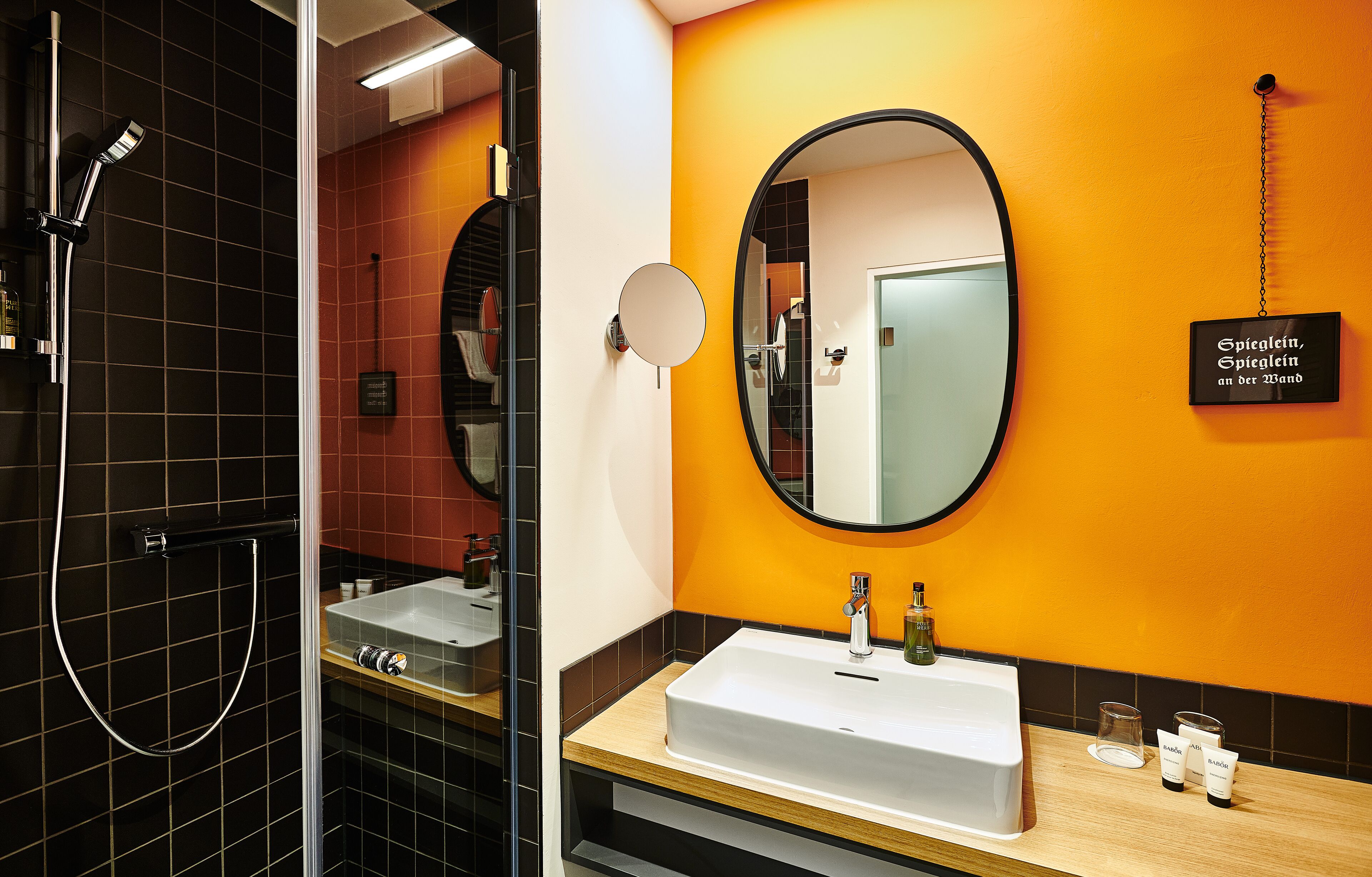 A bathroom with a shower, a sink, and a mirror.
