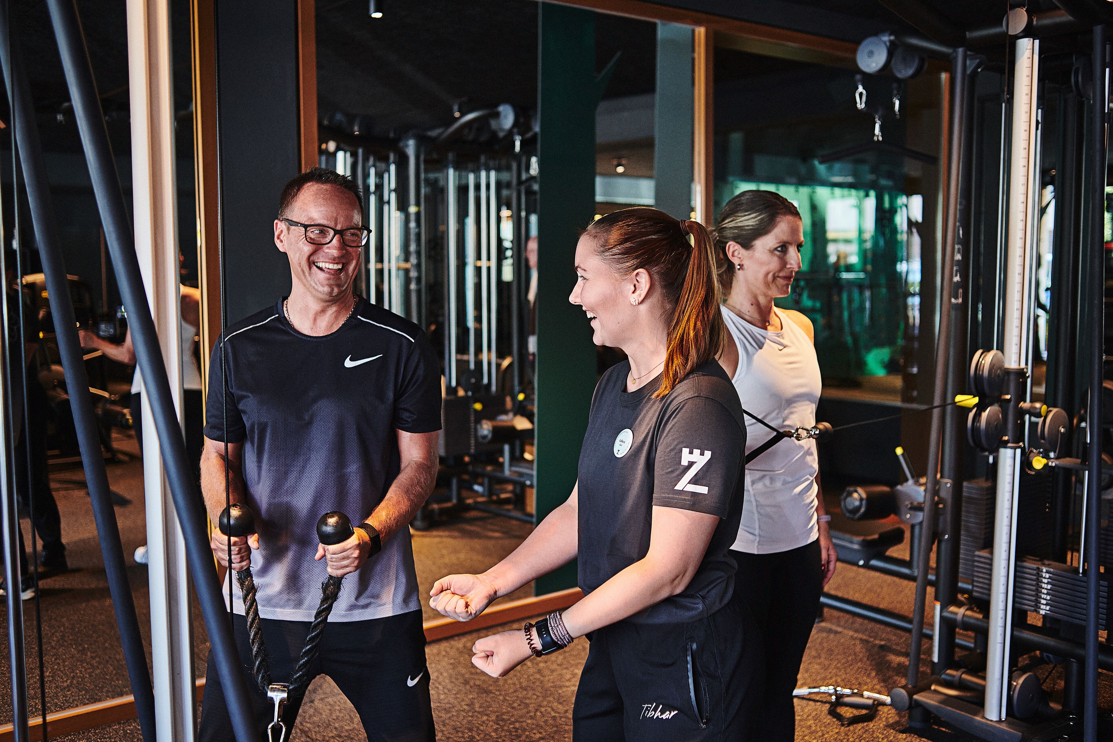 Ett gym med träningsutrustning och speglar.