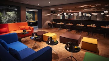 A modern lounge area with sofas, tables, and pendant lighting.