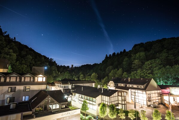 Un pueblo europeo tradicional iluminado de noche, bajo un cielo estrellado.