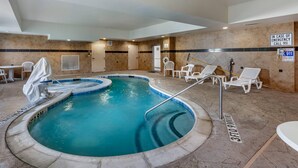 A swimming pool with a 3ft depth marker, lounge chairs, and emergency contact signs. - Comfort Suites Plano - Dallas North (Plano)