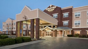 A Country Inn & Suites hotel with a brick facade, a covered entrance, and a clear sky. - Country Inn & Suites by Radisson, Kansas City at Village West, KS (Kansas City)