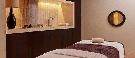 Una habitación de hotel moderna con un espejo grande, una mesita de noche con lámpara y una cama bien hecha.