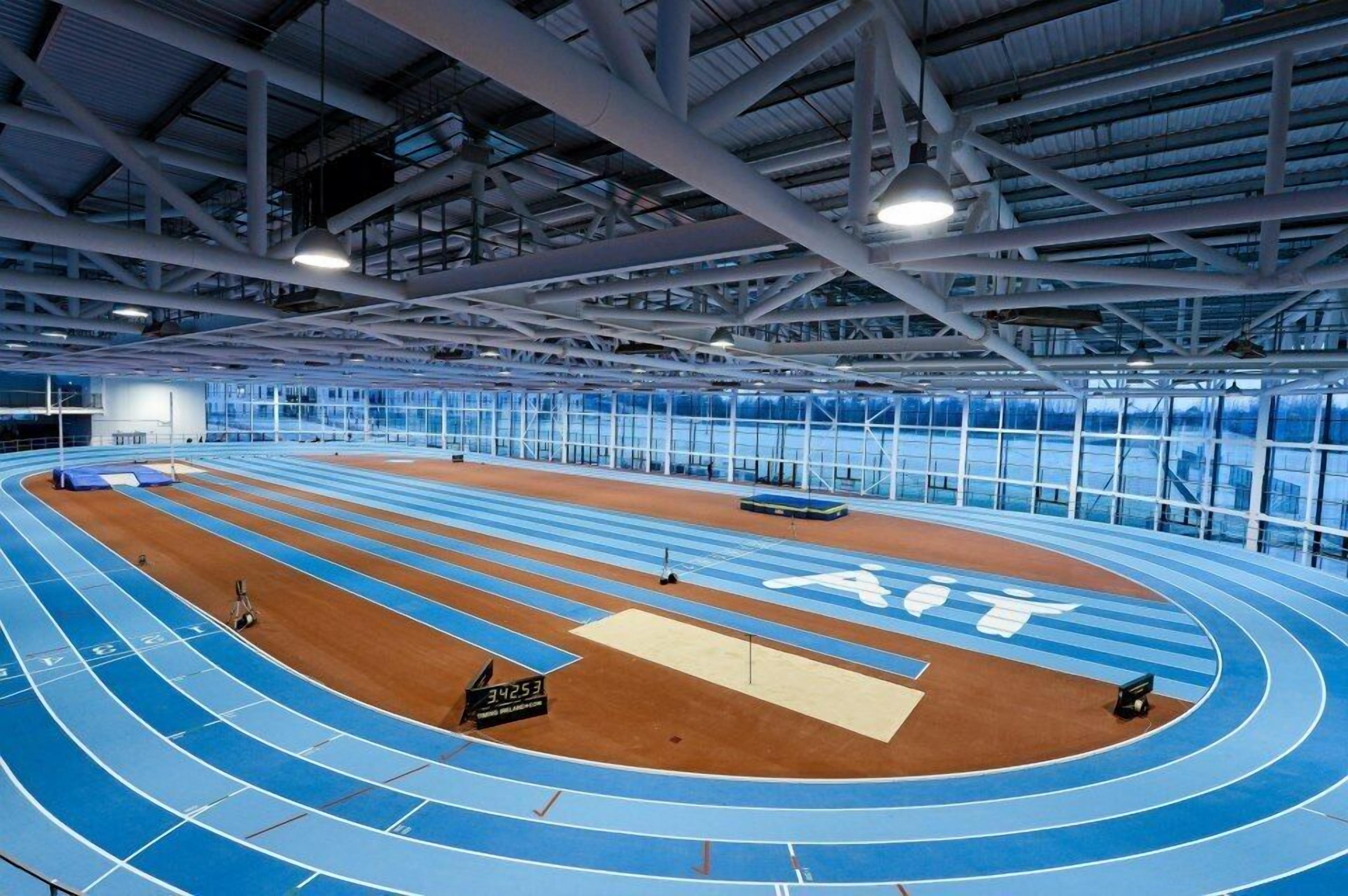 An indoor running track with a high ceiling and large windows.